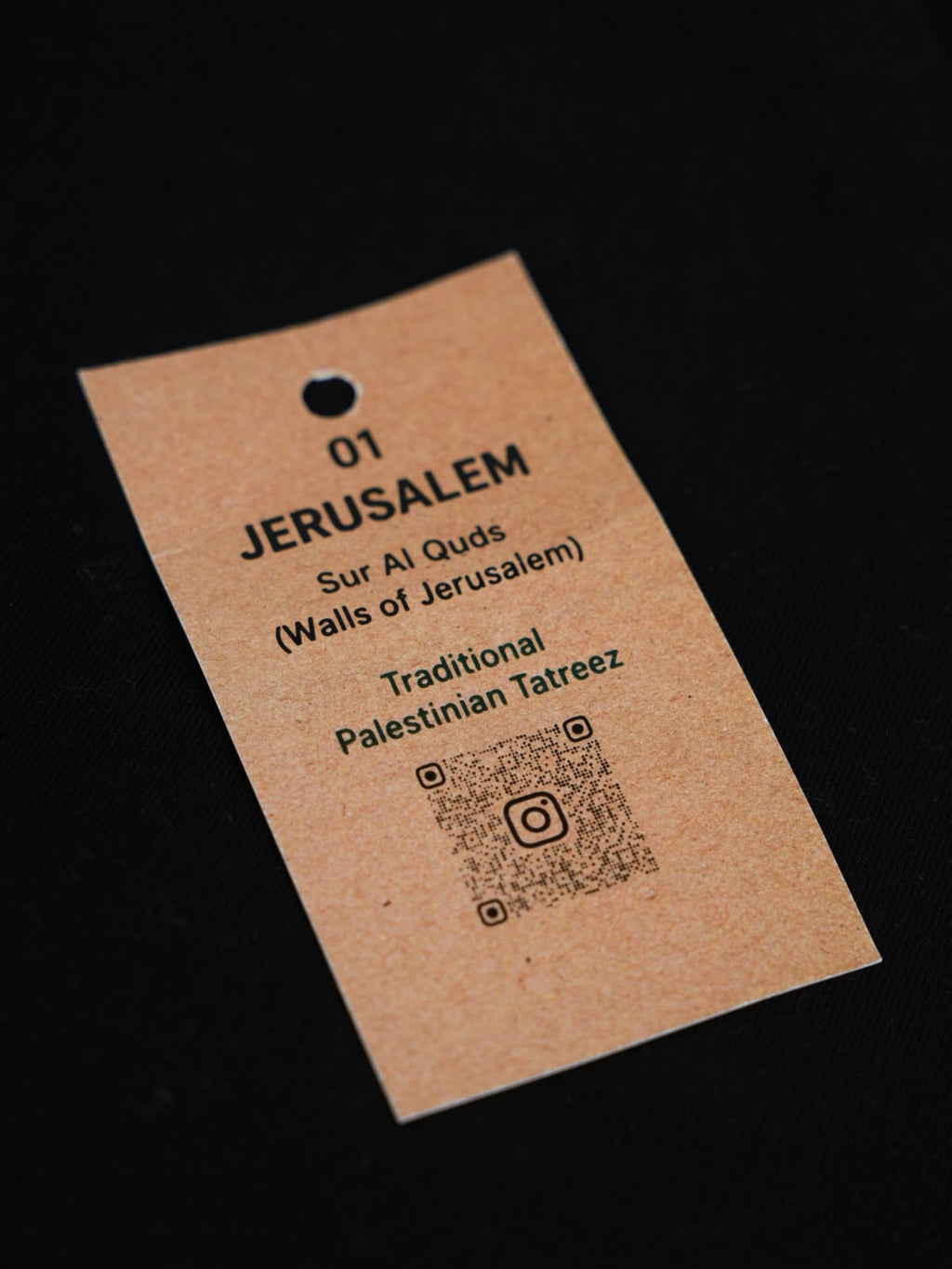 Produktanhänger des Jerusalem Tatreez T-Shirts mit Sur Al Quds Motiv und traditionellem palästinensischem Tatreez