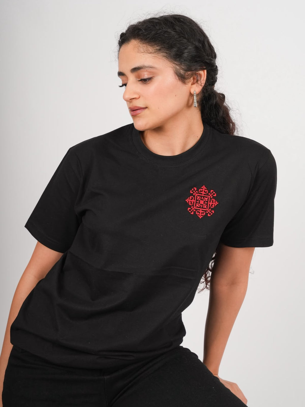 Model mit schwarzem Tatreez T-Shirt und roter handgestickter Sur Al Quds Stickerei auf der linken Brust